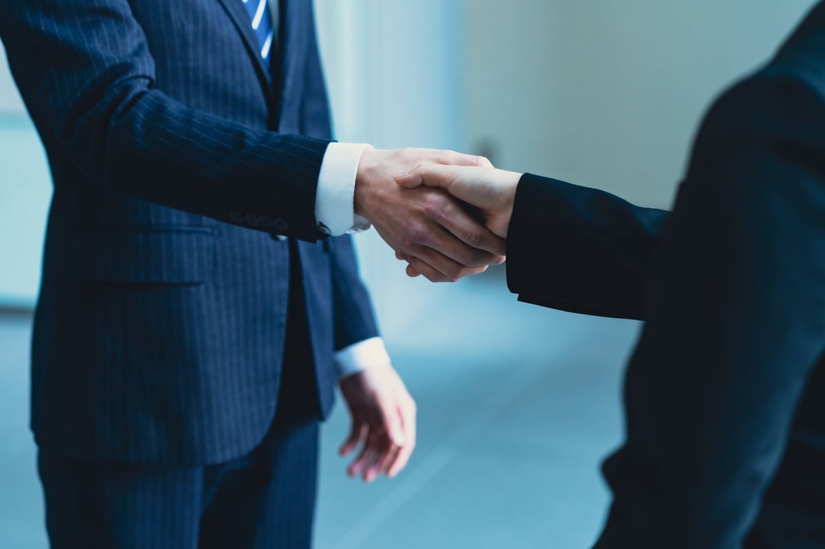 High-profile business professionals shaking hands in a modern office